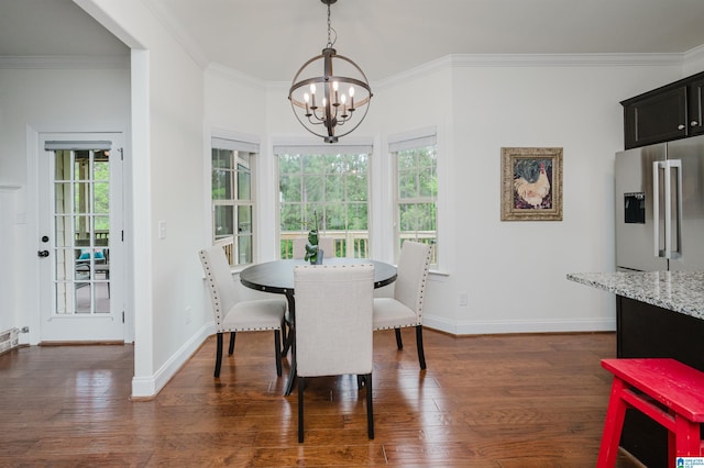 dining room with dark wood finished floors, an inviting chandelier, and crown molding