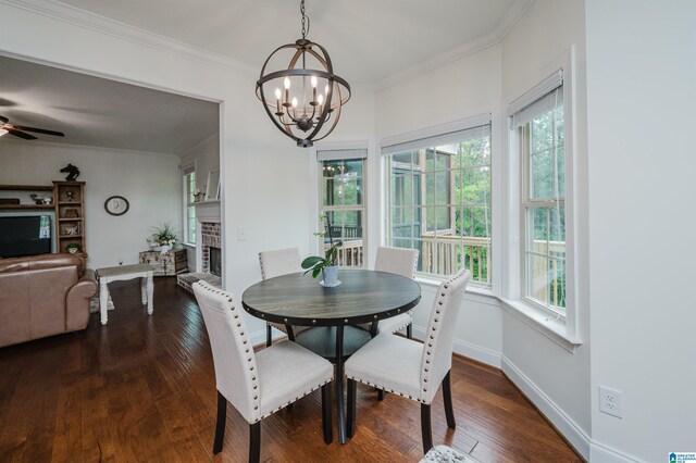 dining area with a wealth of natural light, crown molding, a brick fireplace, and dark wood-style floors