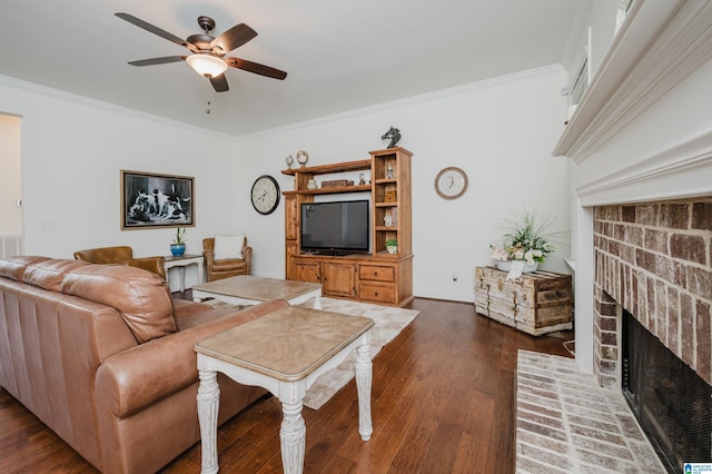living area featuring ceiling fan, dark wood-style flooring, crown molding, and a fireplace
