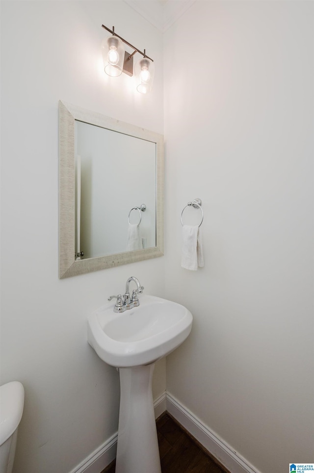 bathroom featuring wood finished floors, baseboards, and toilet