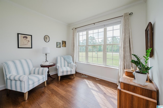 living area featuring wood finished floors, baseboards, and crown molding