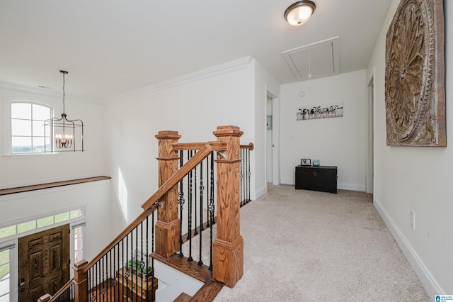 corridor with attic access, baseboards, an inviting chandelier, an upstairs landing, and carpet floors