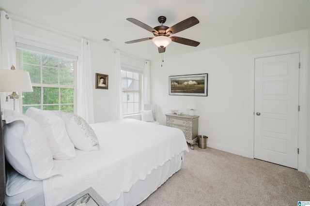 bedroom with light carpet, baseboards, visible vents, and multiple windows