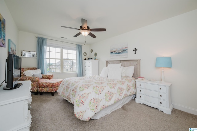 carpeted bedroom with baseboards, a ceiling fan, and visible vents