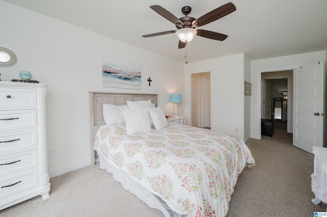 bedroom with a ceiling fan, baseboards, and light carpet