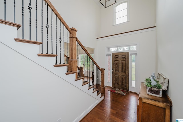 entrance foyer with stairway, a high ceiling, and hardwood / wood-style floors