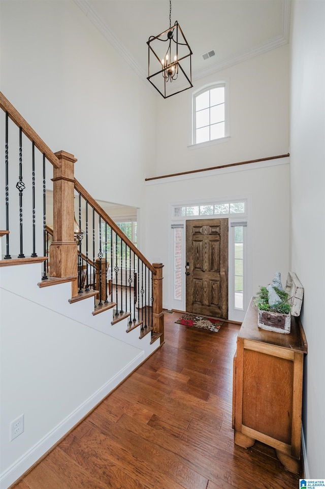 entryway featuring stairway, visible vents, crown molding, and an inviting chandelier
