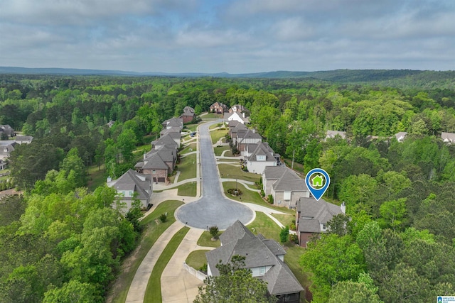 birds eye view of property featuring a residential view and a wooded view