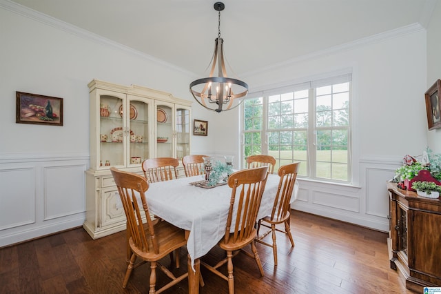 dining area featuring crown molding, an inviting chandelier, and a decorative wall