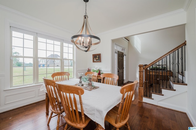 dining area featuring stairway, hardwood / wood-style flooring, ornamental molding, and an inviting chandelier