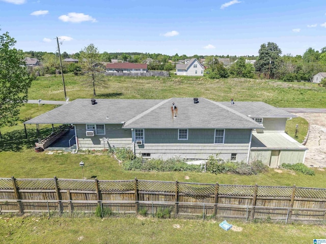 back of house featuring fence and a lawn