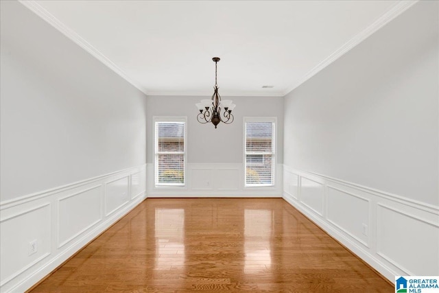 5592 Summit Pointe, Pinson, AL 35126 - unfurnished dining area featuring crown molding, a decorative wall, light wood-style flooring, a wainscoted wall, and a notable chandelier