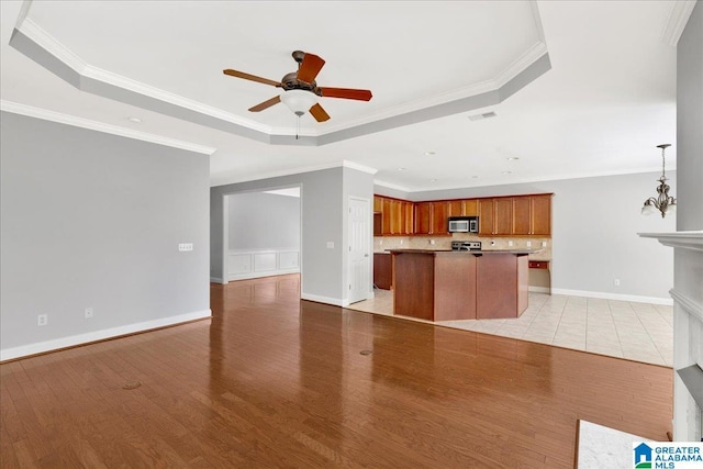 5592 Summit Pointe, Pinson, AL 35126 - unfurnished living room featuring a raised ceiling, crown molding, ceiling fan with notable chandelier, and light wood-style flooring