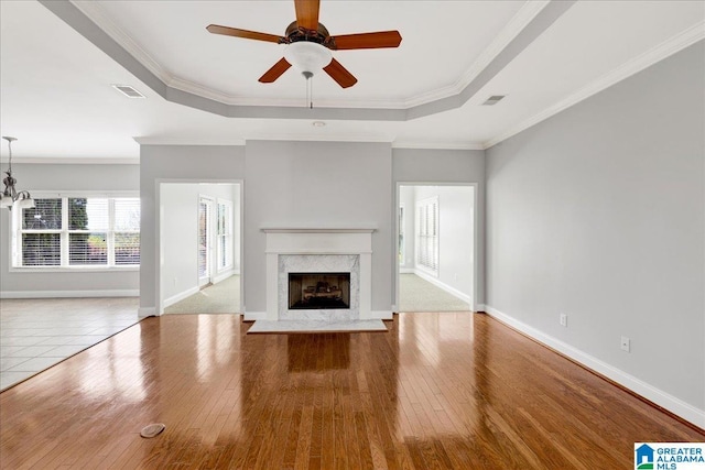 5592 Summit Pointe, Pinson, AL 35126 - unfurnished living room featuring a fireplace, visible vents, a raised ceiling, hardwood / wood-style flooring, and ceiling fan with notable chandelier