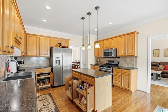 kitchen featuring stainless steel appliances, ornamental molding, a sink, light wood-style floors, and a center island