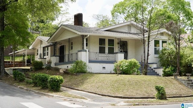 1501 Graymont Ave W, Birmingham, AL 35208 - view of front of home featuring a chimney, covered porch, a front yard, and a shingled roof