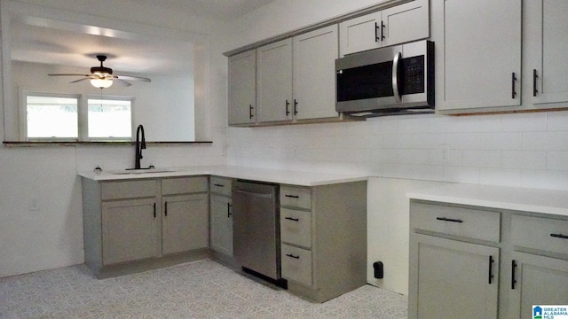 1501 Graymont Ave W, Birmingham, AL 35208 - kitchen with a sink, gray cabinets, backsplash, and stainless steel appliances