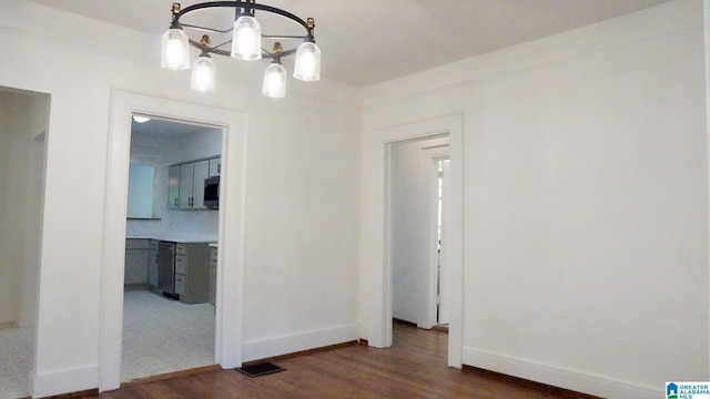 1501 Graymont Ave W, Birmingham, AL 35208 - unfurnished dining area with wood finished floors, a notable chandelier, and baseboards