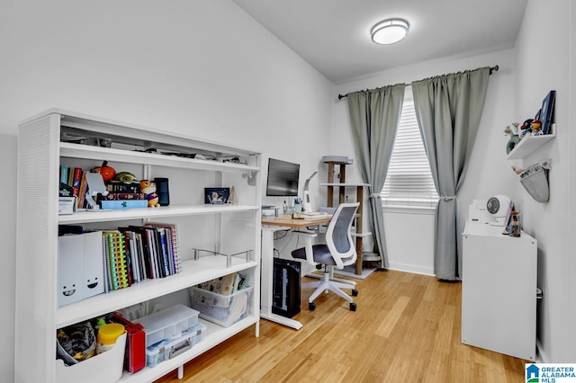home office featuring baseboards and wood finished floors