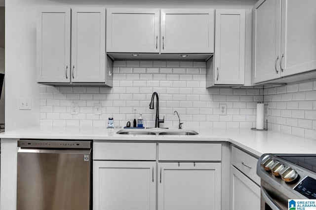 kitchen featuring light countertops, a sink, backsplash, and stainless steel appliances