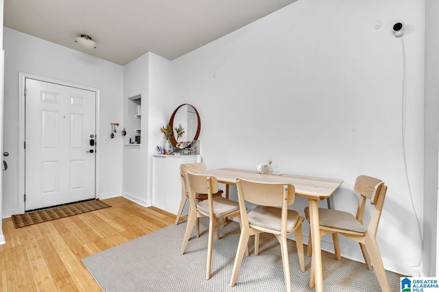 dining area with light wood-type flooring and baseboards