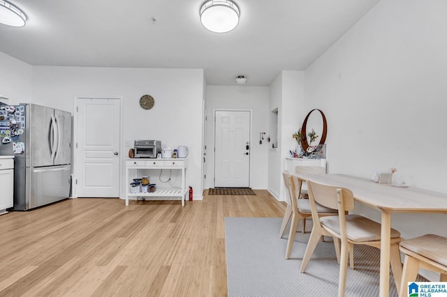 dining area with baseboards and light wood finished floors