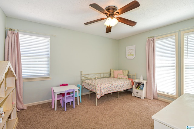 bedroom featuring a ceiling fan, baseboards, light colored carpet, and multiple windows