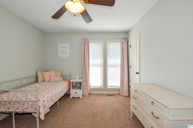 bedroom with light carpet, a ceiling fan, multiple windows, and visible vents