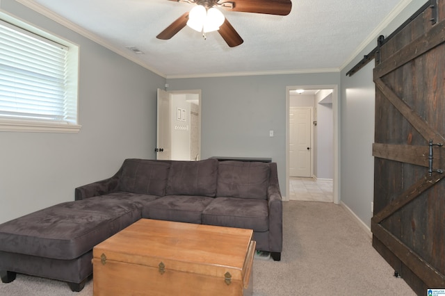 living area with a barn door, visible vents, light carpet, crown molding, and ceiling fan