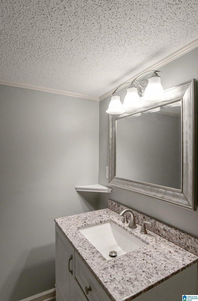 bathroom featuring a textured ceiling, crown molding, and vanity