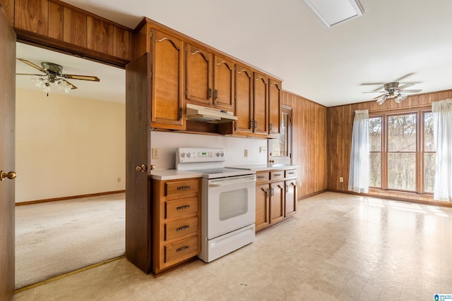 kitchen with brown cabinets, ceiling fan, electric stove, and under cabinet range hood