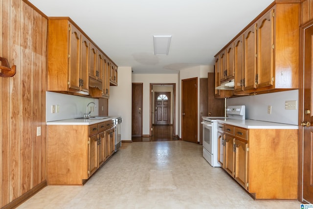 kitchen with white range with electric stovetop, under cabinet range hood, light countertops, and a sink