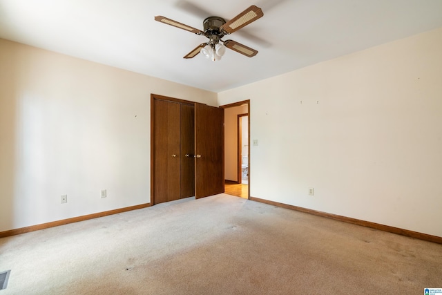 empty room featuring light carpet, ceiling fan, and baseboards