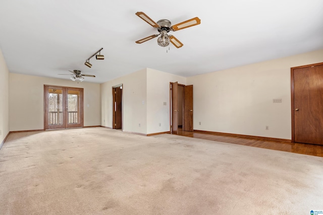 spare room with french doors, ceiling fan, light colored carpet, and baseboards