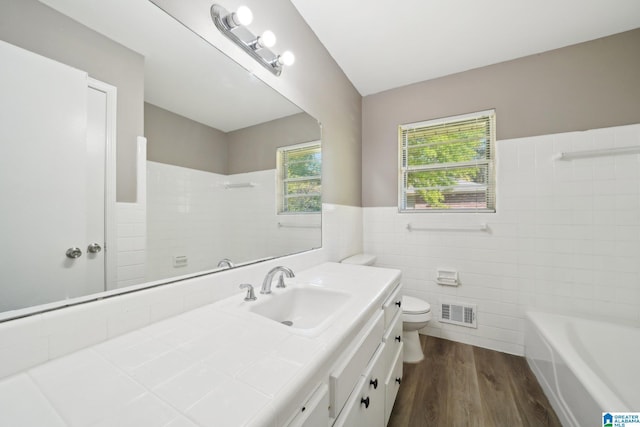 bathroom featuring visible vents, toilet, a shower, wood finished floors, and tile walls