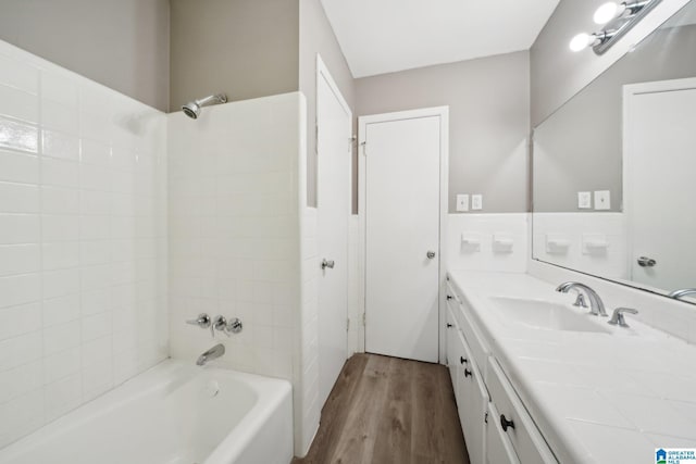 bathroom with shower / washtub combination, wood finished floors, and vanity
