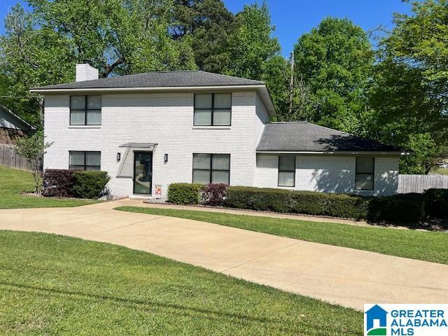 13563 Date St, Northport, AL 35475 - view of front of property featuring a front yard, fence, brick siding, and a chimney