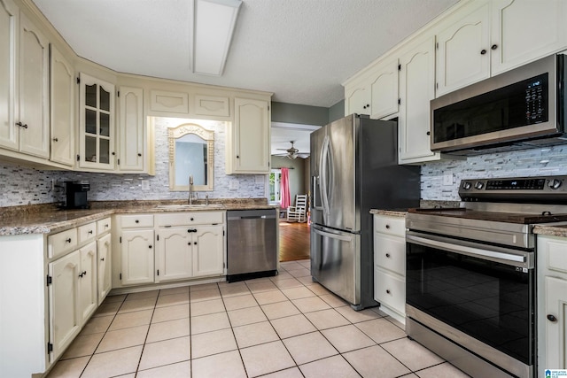 13563 Date St, Northport, AL 35475 - kitchen with light tile patterned floors, tasteful backsplash, a sink, ceiling fan, and stainless steel appliances