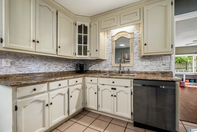 13563 Date St, Northport, AL 35475 - kitchen with light tile patterned floors, dark countertops, stainless steel dishwasher, and a sink