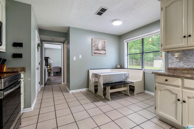 13563 Date St, Northport, AL 35475 - kitchen featuring light tile patterned floors, stainless steel range with electric stovetop, visible vents, and baseboards