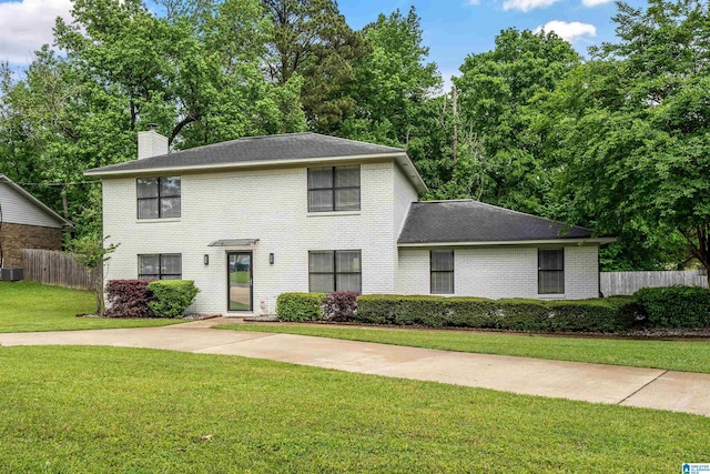 13563 Date St, Northport, AL 35475 - colonial inspired home featuring a chimney, a front yard, fence, central AC, and brick siding