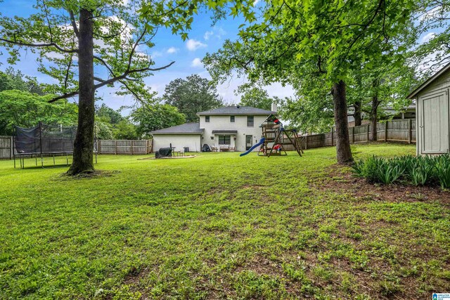 13563 Date St, Northport, AL 35475 - view of yard featuring a fenced backyard, a trampoline, and a playground