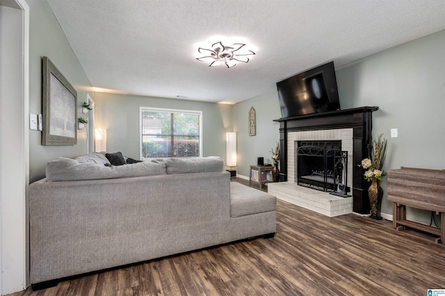 13563 Date St, Northport, AL 35475 - living room featuring baseboards, wood finished floors, a textured ceiling, and a fireplace
