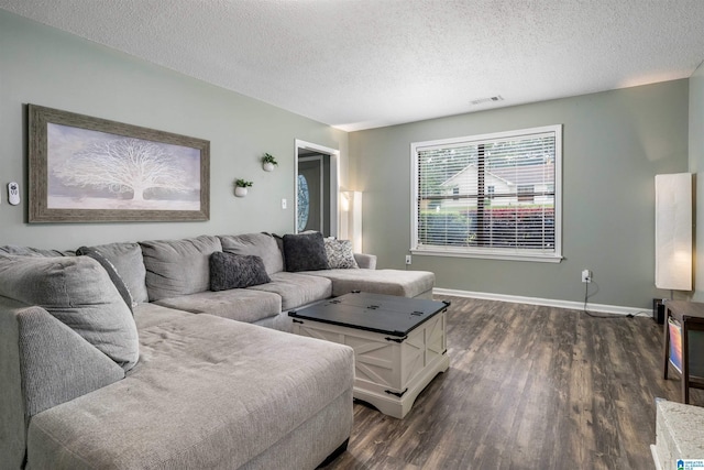 13563 Date St, Northport, AL 35475 - living room featuring a textured ceiling, visible vents, baseboards, and dark wood-type flooring
