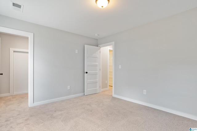 unfurnished bedroom featuring light carpet, baseboards, and visible vents