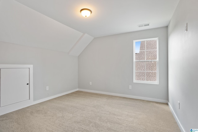 bonus room with visible vents, baseboards, light carpet, and lofted ceiling