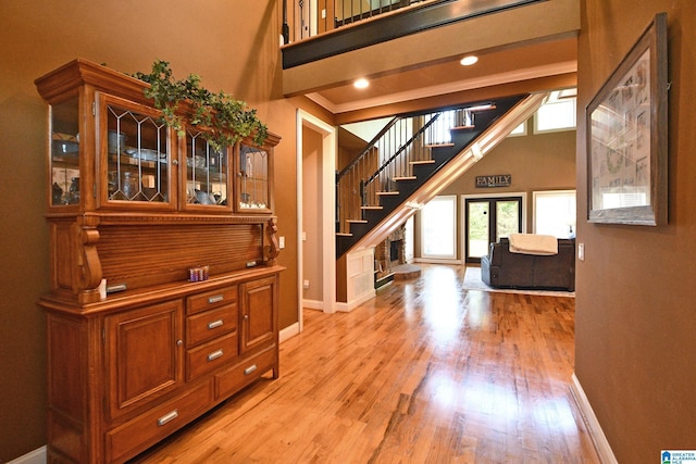 interior space with wood finished floors, a high ceiling, and baseboards