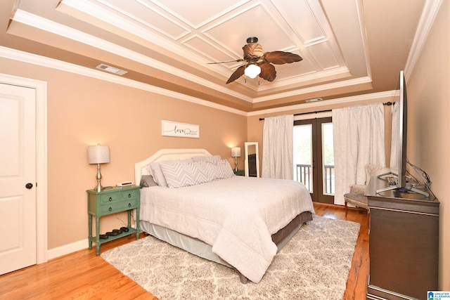 bedroom with light wood-style floors, french doors, a raised ceiling, access to exterior, and visible vents