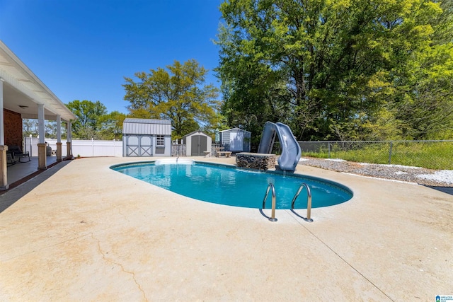 view of swimming pool with a storage shed, a patio area, a water slide, and fence