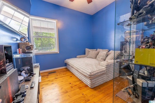 bedroom featuring wood-type flooring, baseboards, a ceiling fan, and visible vents